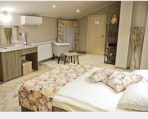 a bedroom with a large bed and a kitchen at Хотел ЛОНДОН in Svilengrad