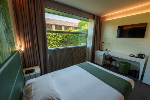 a hotel room with a bed and a large window at Best Western Hotel Green City in Parma