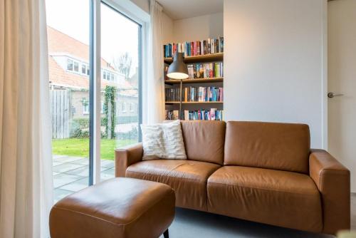 a living room with a couch and a book shelf at De Plevieren in Buren