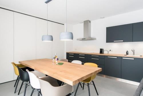 a kitchen with a wooden table and chairs at De Plevieren in Buren