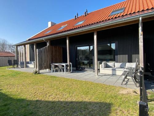 a patio with a couch and a table on a house at De Plevieren in Buren