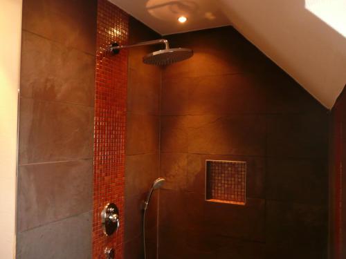 a shower in a bathroom with a brick wall at Hotel im Kavalierhaus in Machern