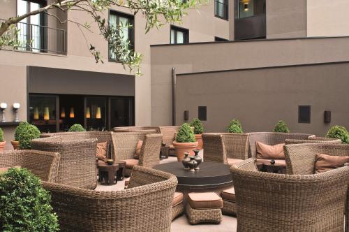 an outdoor patio with wicker chairs and a table at Radisson Blu Hotel Milan in Milan