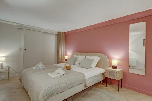 une chambre avec un lit avec un mur rose dans l'établissement 306 Suite Tigre - Superbe Appartement à Paris, à Paris