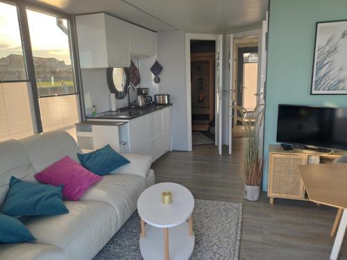 a living room with a couch and a table at Hausboot Fjord Capella - Solarboot in Barth in Barth