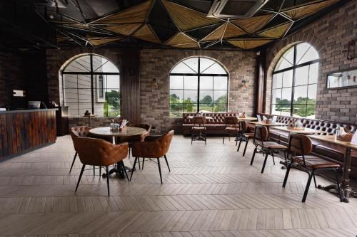 a restaurant with tables and chairs and windows at La Nature Hotels & Resorts in Sīkar