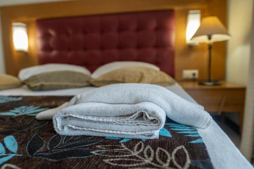 a pile of towels sitting on top of a bed at Scylax Hotels Mahmutlar in Alanya