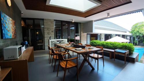 a dining room with a table and chairs at Villa Nusa Dua by Opus Hospitality in Nusa Dua