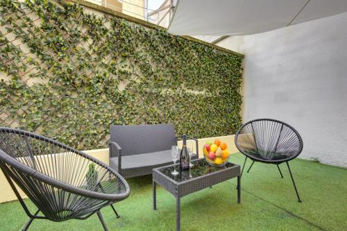a patio with two chairs and a table with fruit on it at 801 Suite Luxurys - Superbe Appartement in Bagnolet