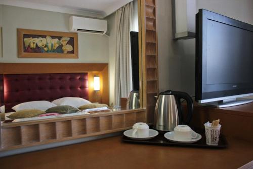 a hotel room with a bed and a large mirror at Scylax Hotels Mahmutlar in Alanya
