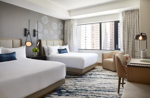 a hotel room with two beds and a desk at InterContinental Seattle Bellevue, by IHG in Bellevue