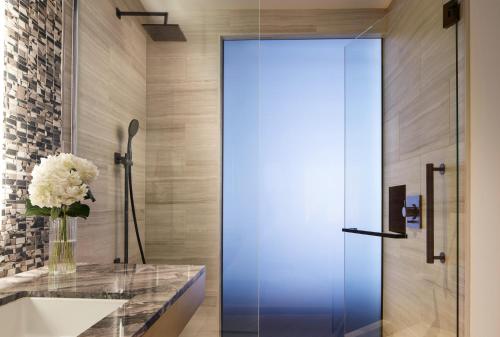 a glass door in a bathroom with a vase of flowers at InterContinental Seattle Bellevue, by IHG in Bellevue