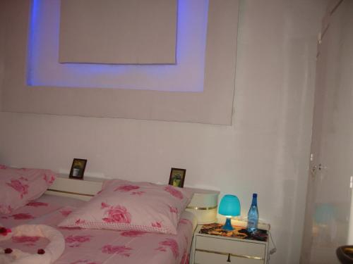 a bedroom with a pink bed and a table with a lamp at KEUR MARIE FAYE in Mbour