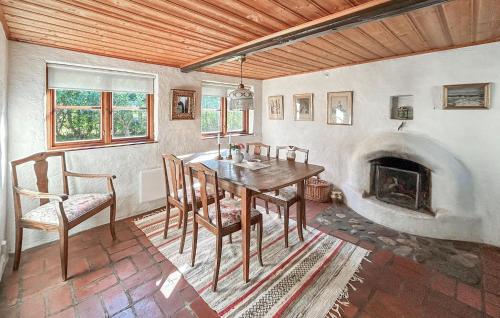 a dining room with a table and a fireplace at 2 Bedroom Beautiful Home In Glemmingbro in Hammar