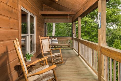 a porch of a cabin with rocking chairs on it at Cabin with amazing long-range mountain views, hot tub, fire pit, EV connection in Boone