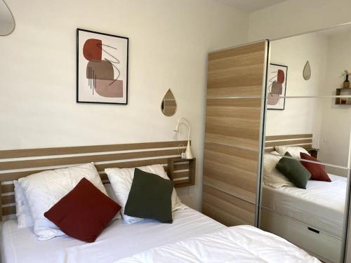 une chambre avec deux lits et un miroir dans l'établissement La loge des mouettes, à Le Touquet-Paris-Plage