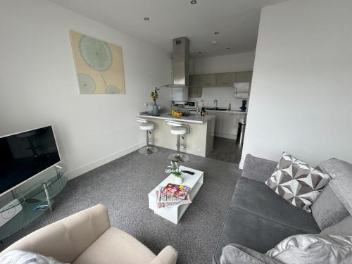 a living room with a couch and a kitchen at Harbour View - 1 Bedroom - Sleeps 2 in Whitehaven