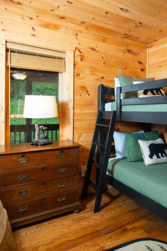 a bedroom with a bunk bed and a dresser at Cabin with amazing long-range mountain views, hot tub, fire pit, EV connection in Boone