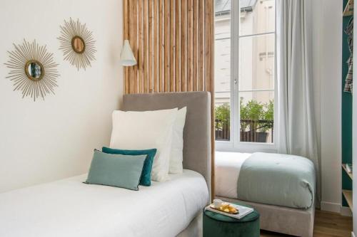 une chambre avec un lit blanc et une fenêtre dans l'établissement My Opera In Paris, à Paris