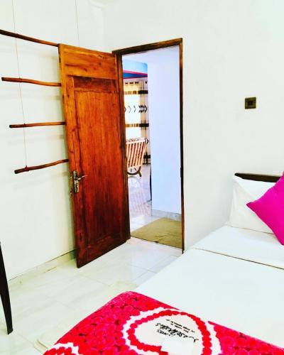 a room with a bed and a door and a mirror at Adisham village home in Haputale