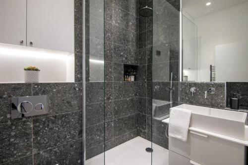 une salle de bain avec une douche en verre avec un lavabo dans l'établissement My Opera In Paris, à Paris