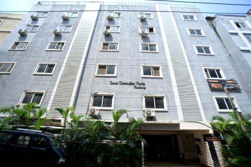 a tall building with a car parked in front of it at Olive Atnest PG in Hyderabad