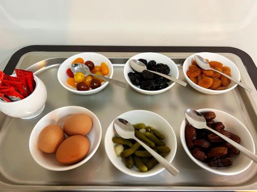 a tray with bowls of fruits and vegetables on it at Hôtel Oden Paris Ivry in Ivry-sur-Seine