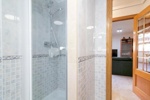 a bathroom with a shower with blue tiles at Global Properties, Apartamento muy cerca de la playa de Puerto de Sagunto in Puerto de Sagunto