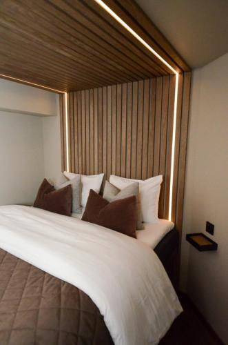 a bedroom with a large white bed with a window at Steam Pier Adventure Hotel in Kvaløya