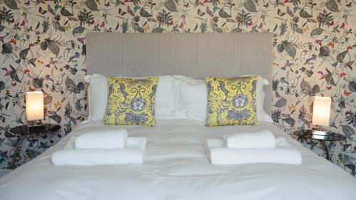 a large white bed with two lamps in a bedroom at 2 Bridge View in Selby