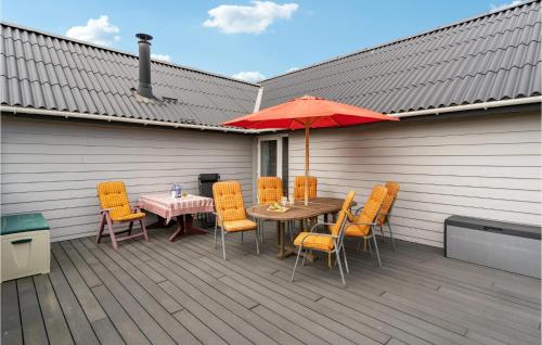 a patio with a table and chairs and an umbrella at 3 Bedroom Amazing Home In Ulfborg in Ulfborg
