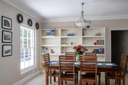 a dining room with a table and chairs and a book shelf at Tokai Forest Guest House in Tokai