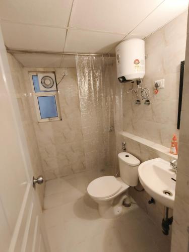 a bathroom with a toilet and a sink at 2BHK 65TV,FullyAC,family,Unmarried Couple,WFO Friendly peacefull place in Noida
