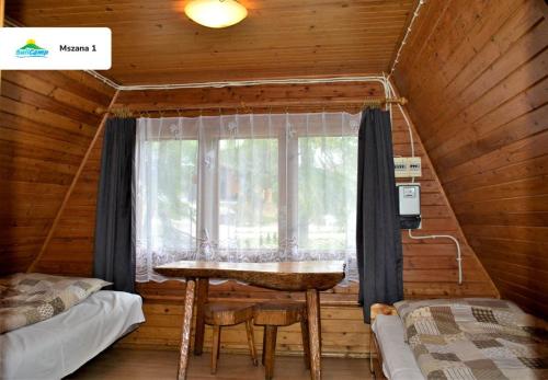 a room with a table and a window in a cabin at SuliCamp Kompleks Wypoczynkowy in Sulistrowice