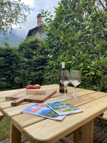 - une table en bois avec une bouteille de vin et 2 verres dans l'établissement Appartement Etoile d'Argent, Fabulous Location, Garden, WIFI, Bike storage, à Allemont