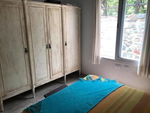 a bedroom with a bed and a window at El Siambon Los Aromos in Siambón