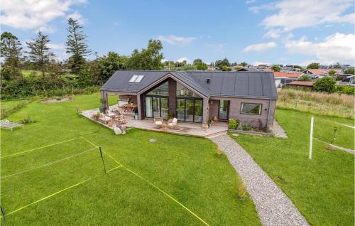 a small house with a large yard with at 3 Bedroom Awesome Home In Otterup in Hasmark