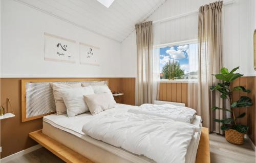 a bedroom with a bed with white sheets and a window at 3 Bedroom Awesome Home In Otterup in Hasmark