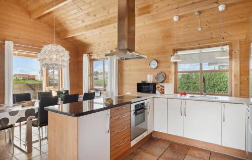 a kitchen with white cabinets and a dining room with a table at Stunning Home In Vinderup With Kitchen in Vinderup