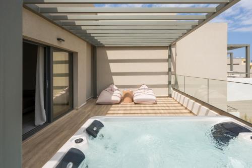 a hot tub on the balcony of a house at Mare Village Hotel in Georgioupolis