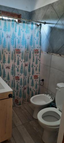 Un baño con inodoro y cortina de ducha. en El Nevado Casa de Campo 1, en San Rafael