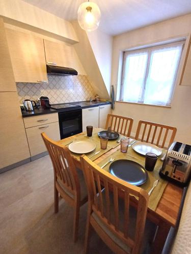 une cuisine avec une table en bois et des chaises ainsi qu'une salle à manger dans l'établissement Confortable Spacieux Grand Rue - Garage, à Saverne