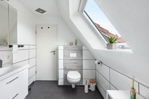 a white bathroom with a toilet and a window at Felsenweg in Lauterbach
