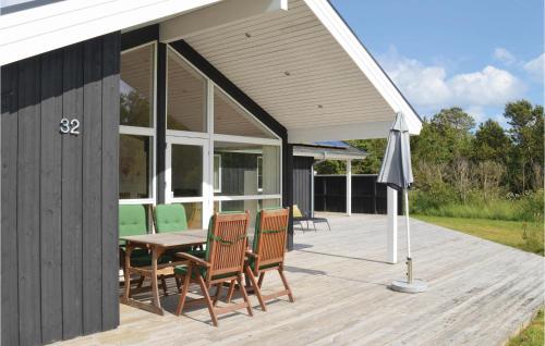 a patio with a table and chairs and an umbrella at Holiday Home Kuskevej Jerup in Jerup