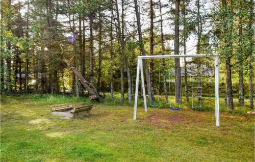 a swing set and a bench in a park at Holiday Home Ved Heksebjerg Blåvand X in Blåvand