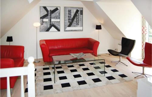 a living room with a red couch and two chairs at Three-Bedroom Holiday Home In Blavand in Blåvand
