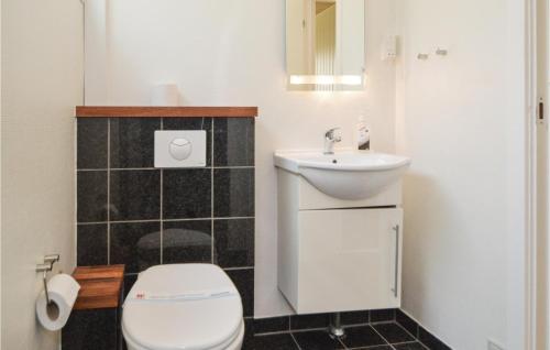a small bathroom with a toilet and a sink at Holiday Home Ved Heksebjerg Blåvand X in Blåvand