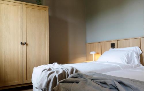 a bedroom with a white bed and a wooden cabinet at Colle Alberti Country House in Cerreto Guidi