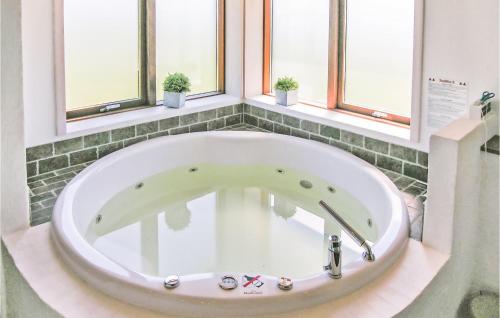a bath tub in a bathroom with windows at Holiday Home Øster Kjulvej Denmk Ii in Hirtshals