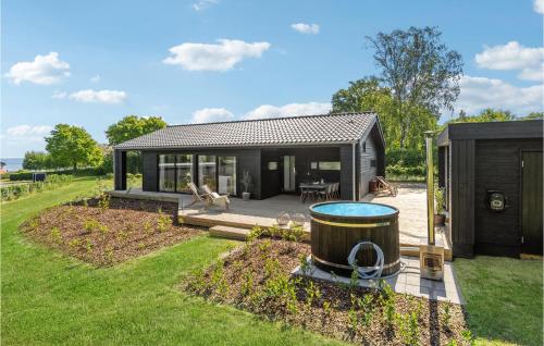 a black house with a barrel in the yard at 3 Bedroom Gorgeous Home In Hadsund in Hadsund